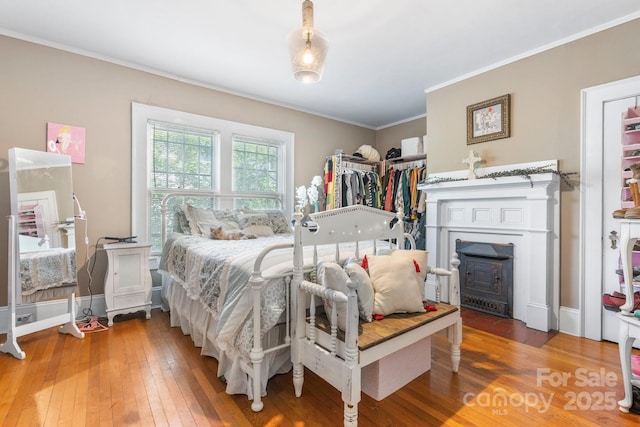 313 E Main St, Morganton, NC 28655 - bedroom with wood-type flooring, ornamental molding, and a wood stove