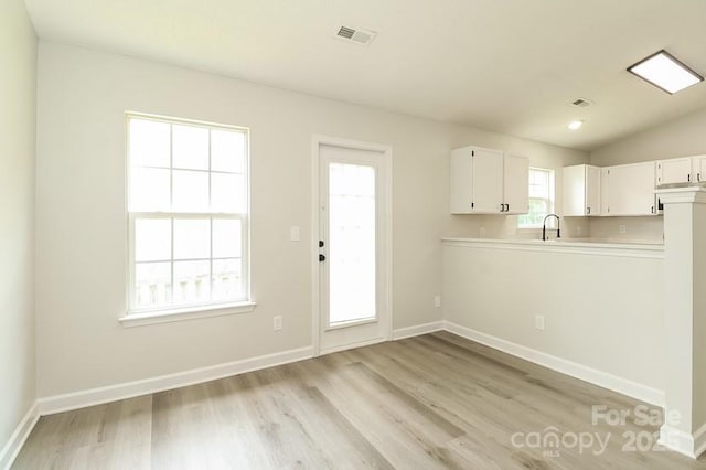 1628 Sandpiper Dr, Rock Hill, SC 29732 - kitchen featuring light countertops, light wood-type flooring, white cabinetry, and vaulted ceiling