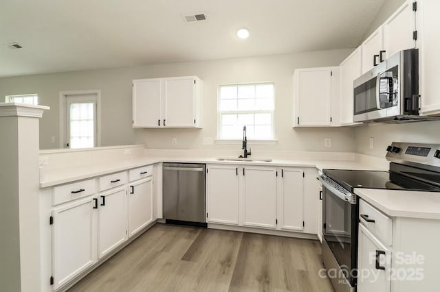 1628 Sandpiper Dr, Rock Hill, SC 29732 - kitchen featuring appliances with stainless steel finishes, plenty of natural light, white cabinetry, light wood finished floors, and recessed lighting