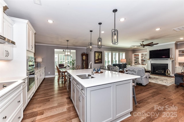 5129 Devonshire Rd, Denver, NC 28037 - kitchen with a ceiling fan, light countertops, a glass covered fireplace, white cabinets, and crown molding
