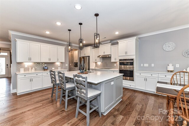 5129 Devonshire Rd, Denver, NC 28037 - kitchen with appliances with stainless steel finishes, ornamental molding, light countertops, white cabinetry, and tasteful backsplash