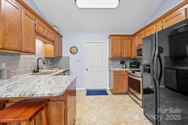 2906 Plantation Way, Albemarle, NC 28001 - kitchen with stainless steel appliances, a peninsula, decorative backsplash, brown cabinetry, and lofted ceiling