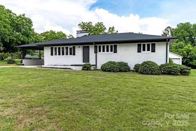 7724 E Holly Grove Rd, Thomasville, NC 27360 - view of front of property with a front lawn, a chimney, brick siding, and an attached carport