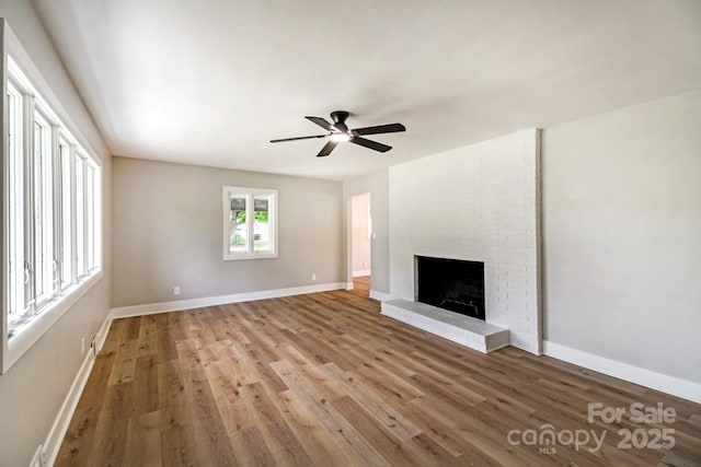 7724 E Holly Grove Rd, Thomasville, NC 27360 - unfurnished living room featuring wood finished floors, a ceiling fan, and a brick fireplace