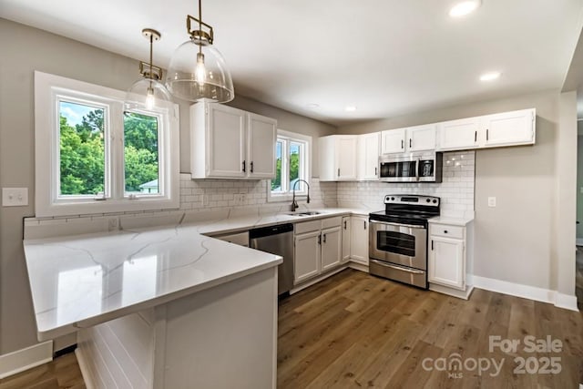7724 E Holly Grove Rd, Thomasville, NC 27360 - kitchen featuring stainless steel appliances, light stone counters, white cabinets, and recessed lighting