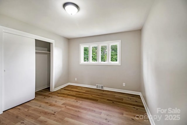 7724 E Holly Grove Rd, Thomasville, NC 27360 - unfurnished bedroom featuring wood finished floors and a closet