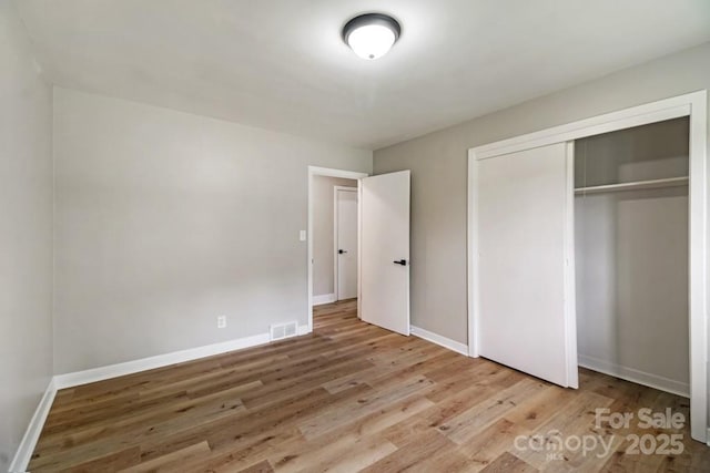 7724 E Holly Grove Rd, Thomasville, NC 27360 - unfurnished bedroom with wood finished floors and a closet