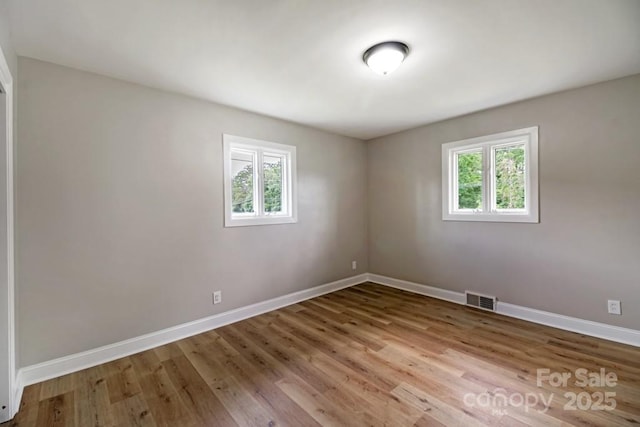 7724 E Holly Grove Rd, Thomasville, NC 27360 - unfurnished room featuring healthy amount of natural light and wood finished floors
