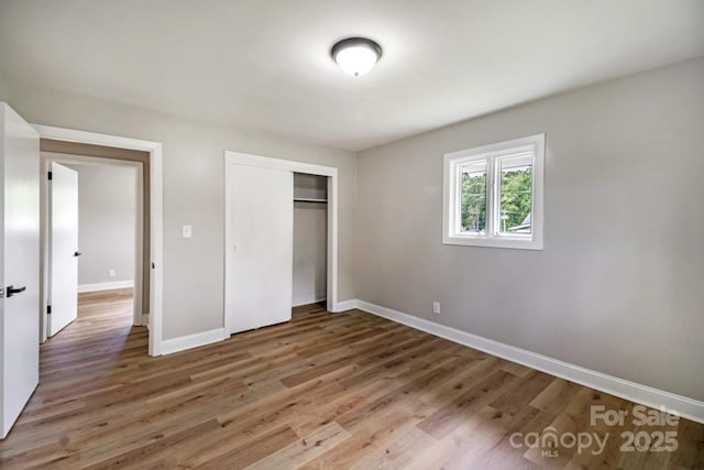7724 E Holly Grove Rd, Thomasville, NC 27360 - unfurnished bedroom with a closet and wood finished floors