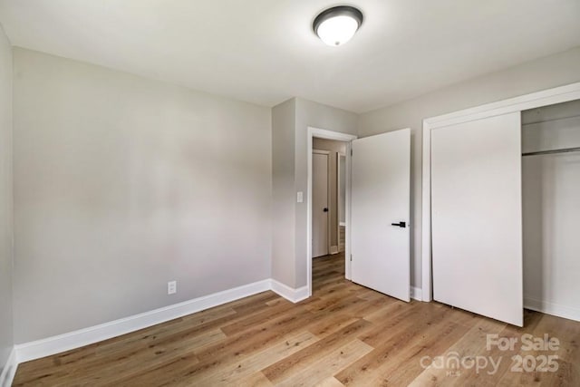 7724 E Holly Grove Rd, Thomasville, NC 27360 - unfurnished bedroom with light wood-style floors and a closet