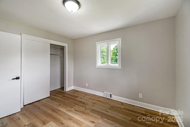 7724 E Holly Grove Rd, Thomasville, NC 27360 - unfurnished bedroom with light wood-style floors and a closet