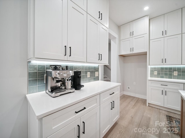2108 Lakeview Cir, Matthews, NC 28105 - kitchen with backsplash, white cabinetry, light wood-style flooring, light countertops, and recessed lighting