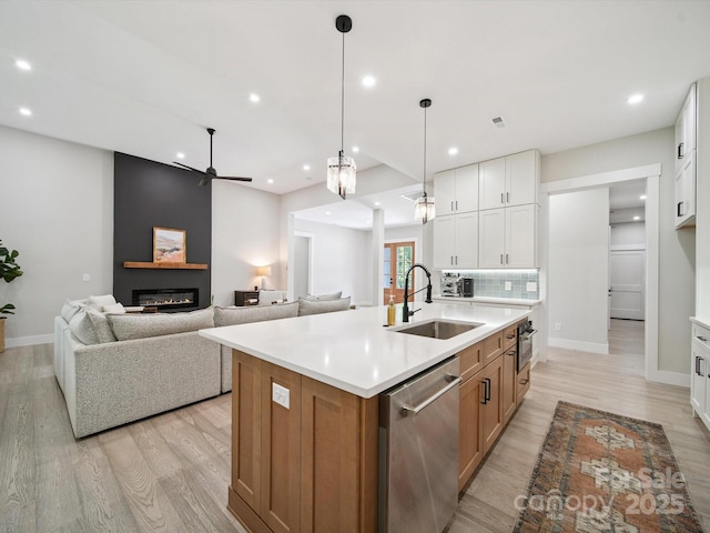 2108 Lakeview Cir, Matthews, NC 28105 - kitchen with stainless steel dishwasher, ceiling fan, light wood-style flooring, recessed lighting, and a large fireplace