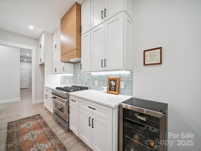 2108 Lakeview Cir, Matthews, NC 28105 - kitchen with beverage cooler, high end stainless steel range, tasteful backsplash, light wood-style flooring, and light countertops