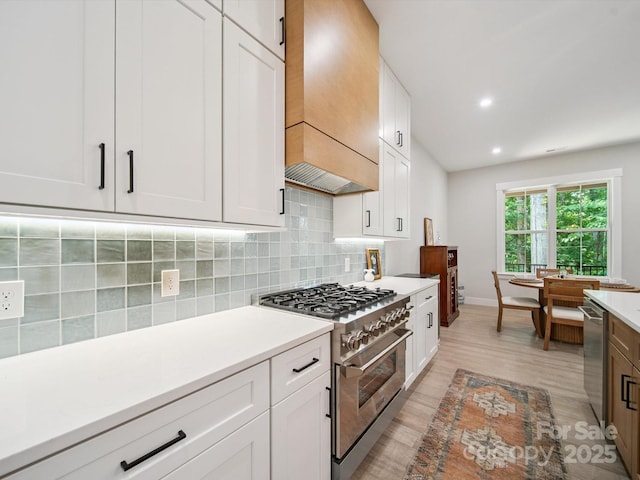 2108 Lakeview Cir, Matthews, NC 28105 - kitchen featuring stainless steel appliances, custom exhaust hood, light wood-style floors, backsplash, and light countertops