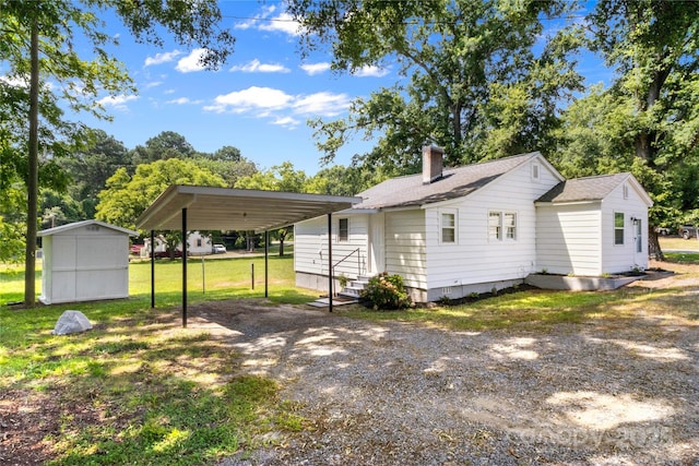 2488 Catawba Church Rd, Rock Hill, SC 29730 - rear view of house featuring a carport, driveway, a shed, a lawn, and a chimney