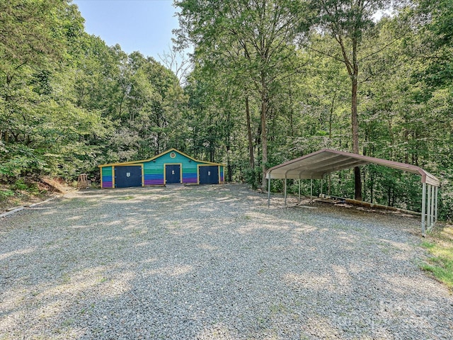 14019 Fountain Ln, Charlotte, NC 28278 - view of yard with driveway, a view of trees, an outbuilding, and a detached garage