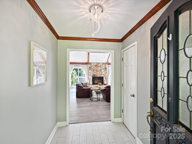 14019 Fountain Ln, Charlotte, NC 28278 - entryway with a chandelier, ornamental molding, a stone fireplace, and light wood-type flooring