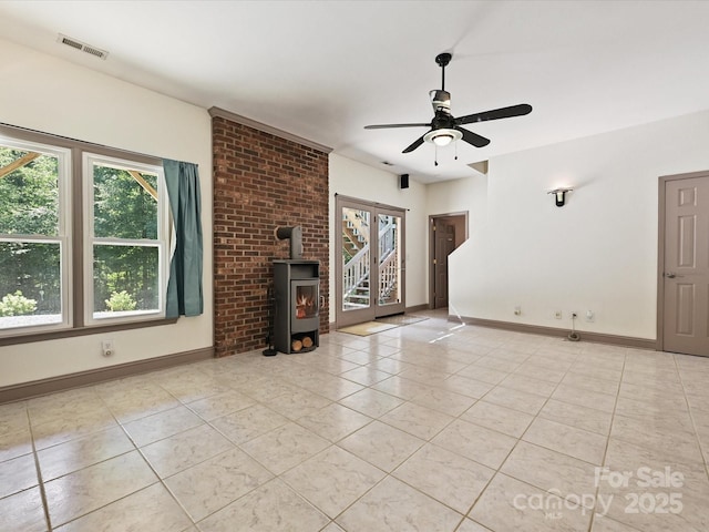 14019 Fountain Ln, Charlotte, NC 28278 - unfurnished living room with healthy amount of natural light, light tile patterned flooring, a ceiling fan, and a wood stove