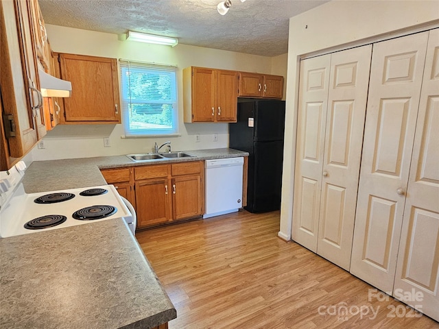 1982 Conley Rd, Morganton, NC 28655 - kitchen with white appliances, under cabinet range hood, light wood-style floors, a textured ceiling, and brown cabinetry