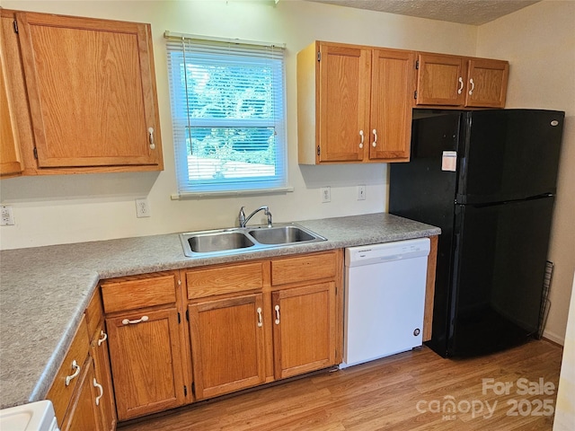 1982 Conley Rd, Morganton, NC 28655 - kitchen with white dishwasher, freestanding refrigerator, light wood-type flooring, brown cabinets, and light countertops