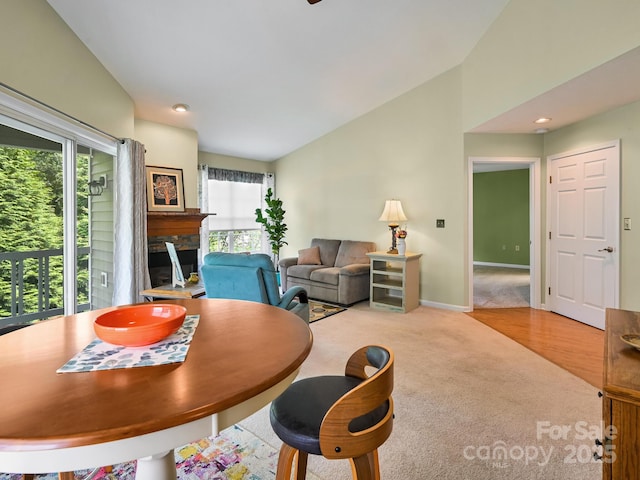 621 E Park Pl, Hendersonville, NC 28791 - dining area featuring healthy amount of natural light, carpet, vaulted ceiling, and a fireplace
