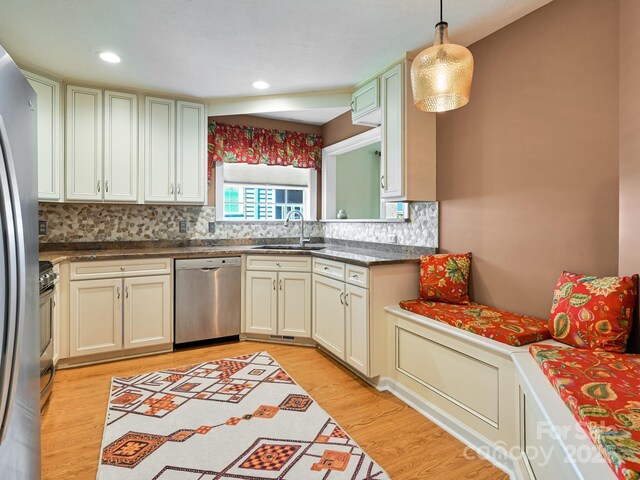621 E Park Pl, Hendersonville, NC 28791 - kitchen with appliances with stainless steel finishes, decorative backsplash, light wood-style floors, hanging light fixtures, and dark countertops