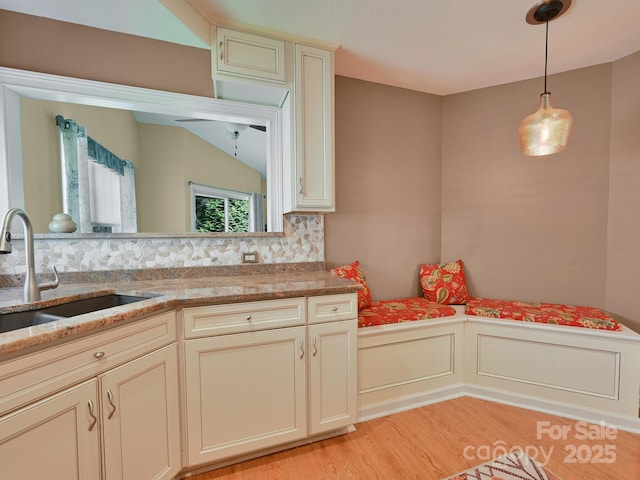 621 E Park Pl, Hendersonville, NC 28791 - kitchen with light wood-style flooring, backsplash, decorative light fixtures, and light stone countertops