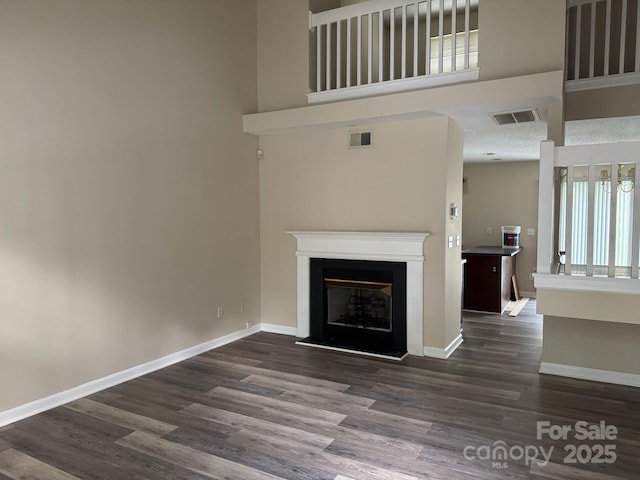 1814 Birch Heights Ct, Charlotte, NC 28213 - unfurnished living room featuring dark wood-style floors, a fireplace, and a towering ceiling