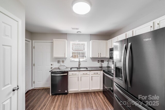 5116 Crane Point Dr, Charlotte, NC 28227 - kitchen with appliances with stainless steel finishes, white cabinetry, wood finished floors, and dark stone countertops