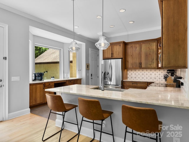102 Gap Creek Rd, Fletcher, NC 28732 - kitchen featuring stainless steel fridge with ice dispenser, brown cabinets, tasteful backsplash, a peninsula, and light stone countertops