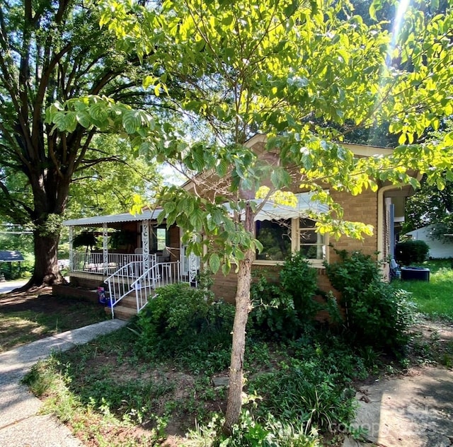 3702 Crawford St, Gastonia, NC 28052 - view of property hidden behind natural elements with a porch and brick siding