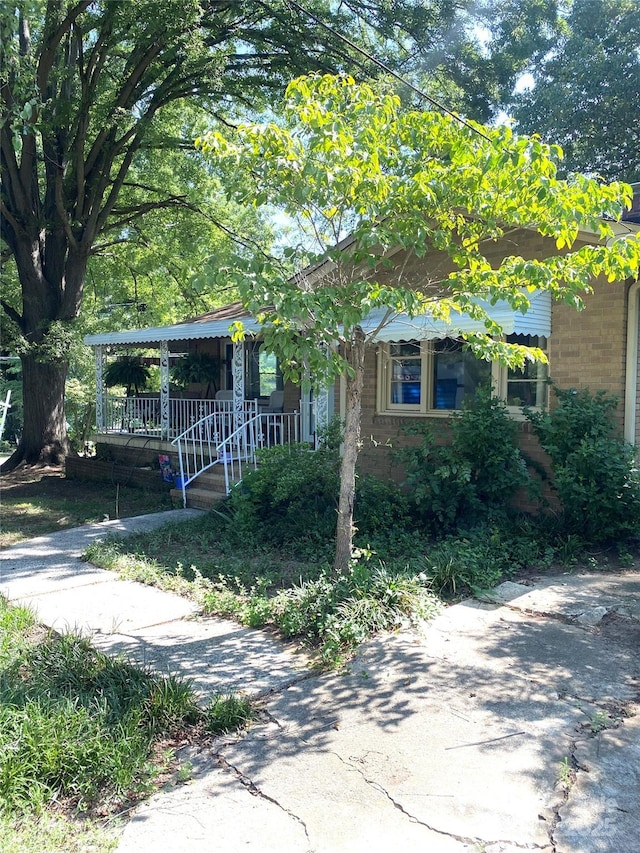3702 Crawford St, Gastonia, NC 28052 - view of property hidden behind natural elements with brick siding and a porch