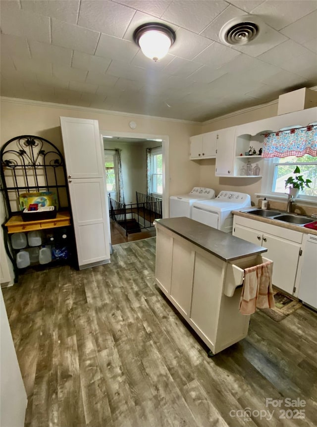 3702 Crawford St, Gastonia, NC 28052 - kitchen with washer and clothes dryer, white cabinets, healthy amount of natural light, and crown molding