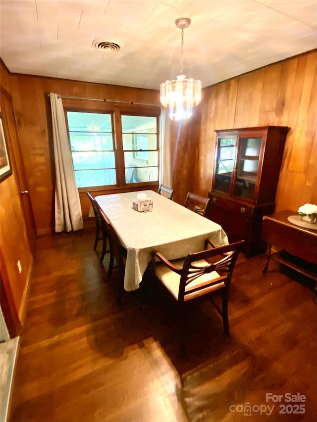 3702 Crawford St, Gastonia, NC 28052 - dining room featuring wood walls, a chandelier, and dark wood-type flooring