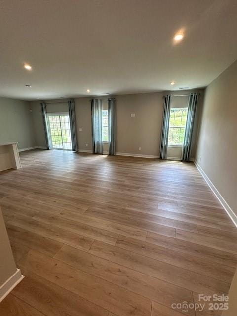 1411 Cottage Green Dr Unit 218, Monroe, NC 28112 - empty room with plenty of natural light, wood finished floors, and recessed lighting