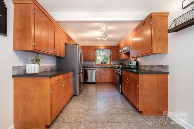 4919 Rehobeth Rd, Waxhaw, NC 28173 - kitchen featuring appliances with stainless steel finishes, under cabinet range hood, dark countertops, and brown cabinets