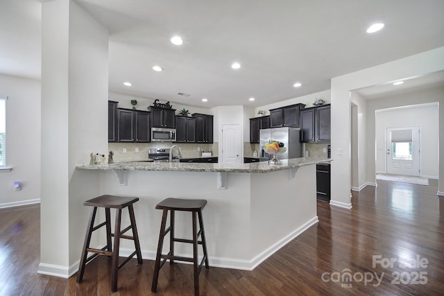 248 Catoctin Rd, Rock Hill, SC 29732 - kitchen with appliances with stainless steel finishes, backsplash, light stone counters, dark wood finished floors, and recessed lighting