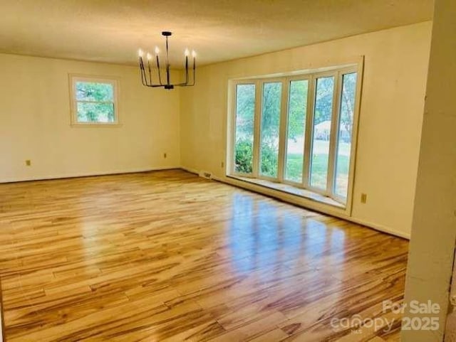 2660 Tiffany St, Conover, NC 28613 - spare room featuring wood finished floors and a chandelier