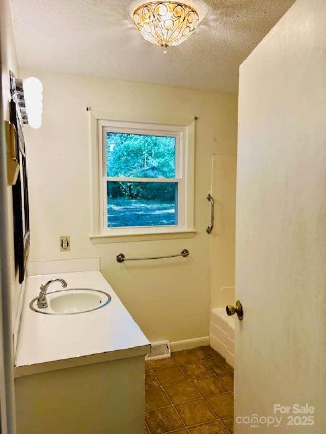 2660 Tiffany St, Conover, NC 28613 - full bath featuring vanity, a textured ceiling, and shower / washtub combination
