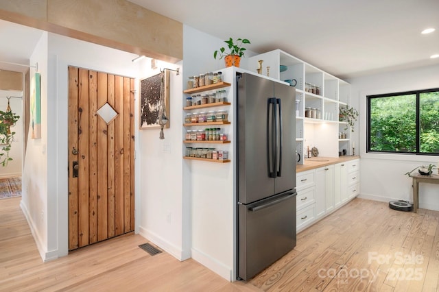 136 Graveyard Rd, Fairview, NC 28730 - kitchen with freestanding refrigerator, open shelves, light wood-style floors, white cabinetry, and light countertops