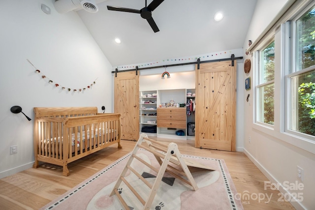 136 Graveyard Rd, Fairview, NC 28730 - bedroom featuring a barn door, wood finished floors, multiple windows, high vaulted ceiling, and recessed lighting