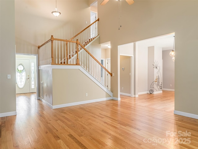 19 Driftstone Cir, Arden, NC 28704 - unfurnished living room with a high ceiling, stairway, wood finished floors, and ceiling fan