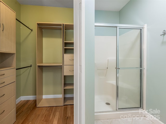 19 Driftstone Cir, Arden, NC 28704 - bathroom featuring a stall shower, wood finished floors, and a walk in closet