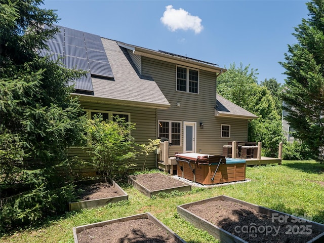 19 Driftstone Cir, Arden, NC 28704 - back of house featuring a vegetable garden, solar panels, a shingled roof, and a lawn