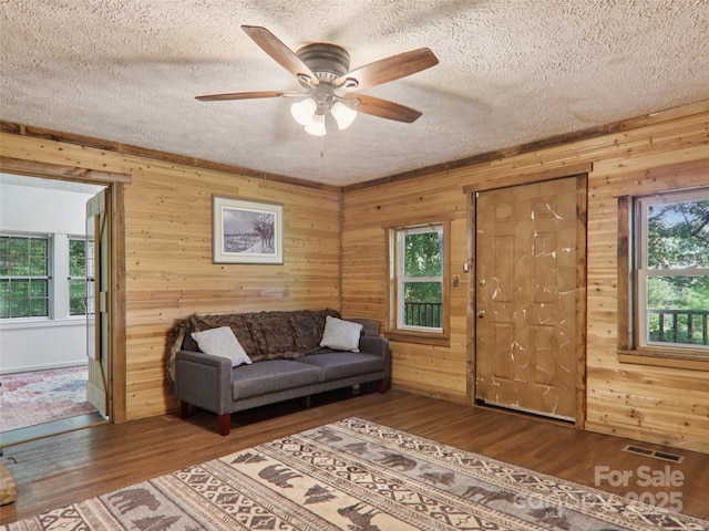32 Saunooke Rd, Asheville, NC 28805 - living area featuring wood walls, wood finished floors, a textured ceiling, and a ceiling fan