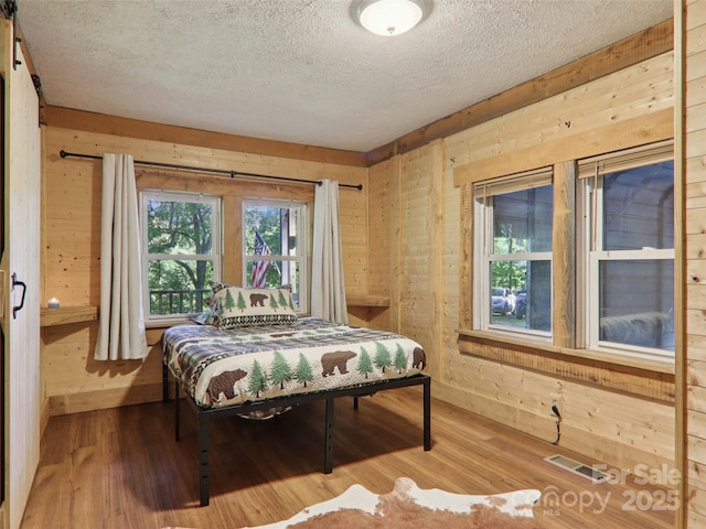 32 Saunooke Rd, Asheville, NC 28805 - bedroom featuring a textured ceiling, wood finished floors, and wooden walls