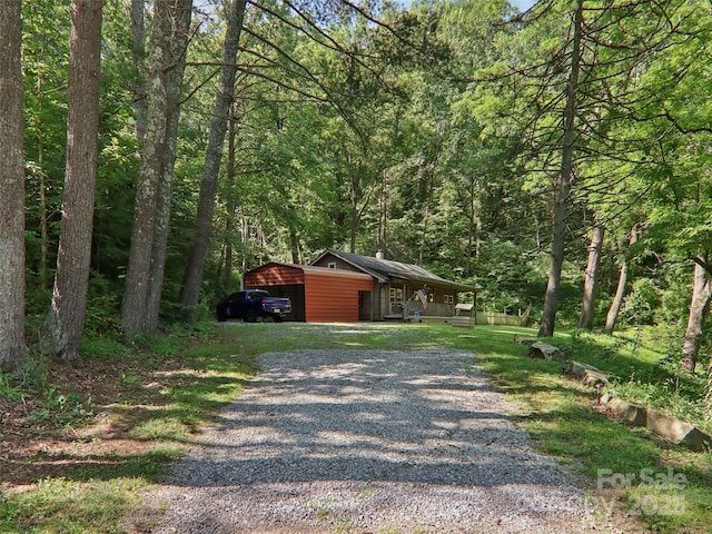 32 Saunooke Rd, Asheville, NC 28805 - view of front of house featuring gravel driveway, a wooded view, covered porch, and a carport