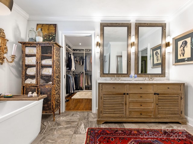 3001 Colony Rd, Charlotte, NC 28211 - bathroom featuring marble tiled floors, a freestanding bath, vanity, crown molding, and a walk in closet