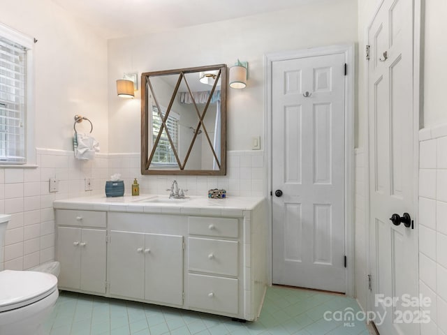 3001 Colony Rd, Charlotte, NC 28211 - bathroom with tile walls, tile patterned floors, vanity, and wainscoting